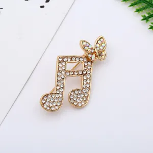 Detailed view of gold rhinestone musical note butterfly brooch, sparkling crystal jewelry.