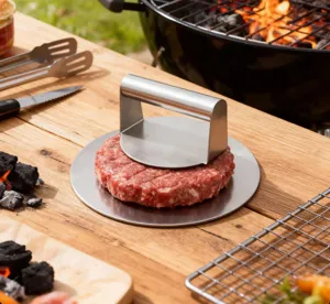 Dettaglio della pressa per hamburger in acciaio inossidabile che modella la carne al barbecue.