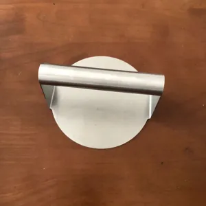 Dettaglio pressa per hamburger in acciaio inox, strumento robusto per cucina.