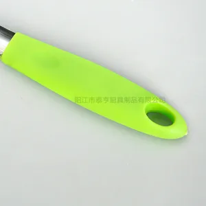 Stainless steel apple corer handle detail with green silicone grip and hanging hole.