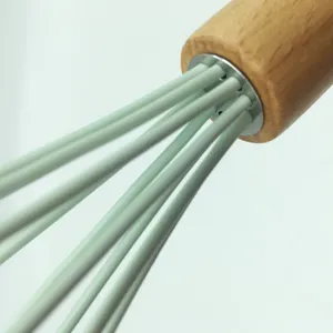 Silikon Schneebesen Holzgriff Detailansicht, professionelle Backwerkzeug Verbindung Nahaufnahme.