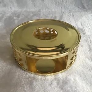 Gold stainless steel tea warmer detail view, hollow design for candle heating, elegant table accent.