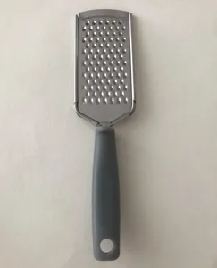 Detailansicht der Edelstahl Flachreibe mit scharfen Klingen und ergonomischem grauen Griff.