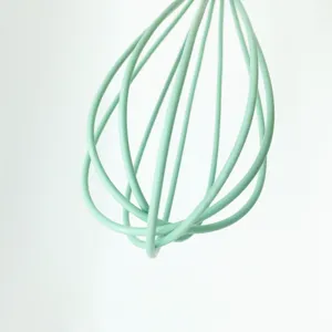 Detailaufnahme eines mintgrünen Silikon-Schneebesens, flexible Drähte zum Backen Mixen.
