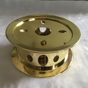Golden metal tea warmer detail showcasing the hollow round ventilation holes and polished finish.