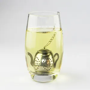 Stainless steel teapot shaped tea infuser detail shot showing tea brewing in a glass.