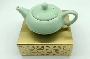Seladon Keramik Teekanne mit edlem titan goldenem hohlem Teewärmer Sockel im Detail.