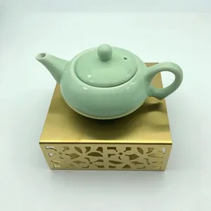 Teiera in ceramica verde chiaro con base riscaldante in metallo dorato, pratico scaldataè.