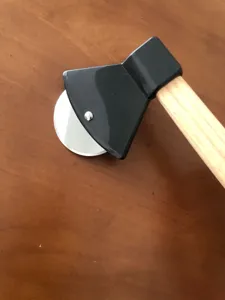 Stainless steel pizza cutter with axe shape and wood handle for kitchen baking detail view