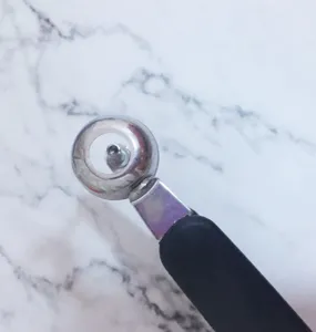 Détail de dénoyauteur de cerises en inox, outil de cuisine pratique pour le fruité et salade.