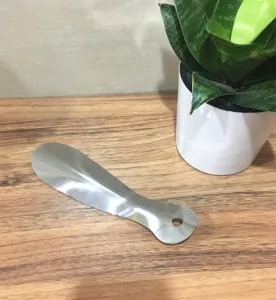 Stainless steel shoehorn detail view, portable metal shoe lifting tool with hanging hole design.