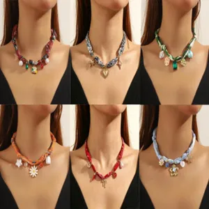 Nahaufnahme Detailansicht modischer Stoffbänder-Choker-Halsketten mit hübschen Blumen-Anhängern.