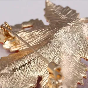 Close-up detail of the maple leaf brooch back showing fine metal texture and sturdy pin clasp.