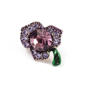 Nahaufnahme Detail der exquisten lila Kristall Strass Brosche mit emailliertem grünen Stiel.