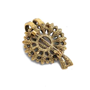 Vintage gold alloy brooch pin back view showing intricate floral wreath design and clasp.