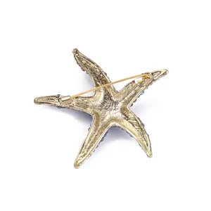 Gold-tone alloy starfish brooch back view with secure pin clasp and rhinestone details.