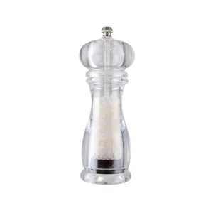 Clear acrylic pepper and salt grinder detail, manual spice mill showing coarse salt inside.