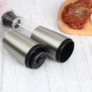 Stainless steel electric pepper grinder detail showing battery compartment and transparent body.