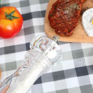 Detailed close-up of a transparent acrylic salt and pepper grinder showcasing coarse salt inside.