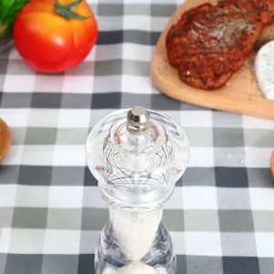 Acrylic pepper grinder detail showing the transparent body and ceramic mechanism close up.