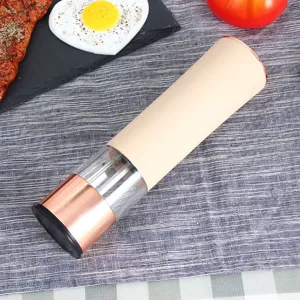 Moulin à poivre électrique élégant avec accent or rose et corps beige pour la cuisine.