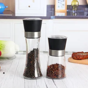 Vue détaillée de moulins à poivre manuels en verre dans une cuisine, texture claire et design.