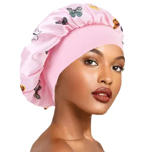 Detailed view of the pink satin sleep cap featuring a wide elastic brim and butterfly print.