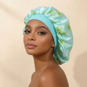 Close-up detail of soft mint green satin sleep cap with lovely green floral print and elastic band.