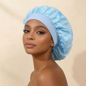 Detailed view of the light blue satin double layer sleep cap with delicate floral embroidery and elastic.
