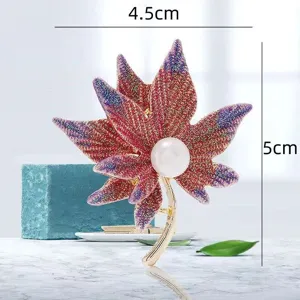 Broche feuille d'érable exquise avec finition scintillante et perle centrale.
