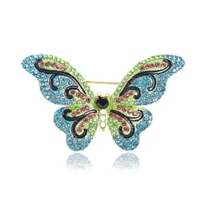 Broche de mariposa psicodélica estilo bosque con pedrería azul verde rosa y elegante diseño.