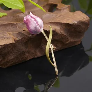 Close-up of elegant purple tulip brooch with gold stem on rustic wood background for daily.