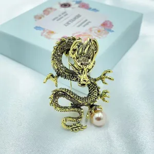 Broche de dragón retro dorado con brillantes diamantes de imitación y perla rosa.