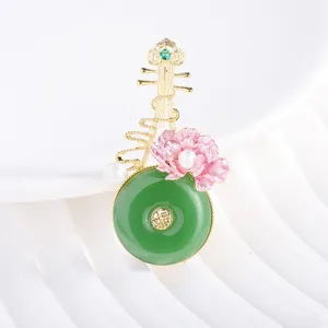 Chinese style pipa brooch featuring green jade-like ring, pink enamel flower and pearls. Detail view.