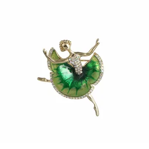 Detailed close-up of a sparkling crystal ballerina brooch with green enamel skirt and gold tone.