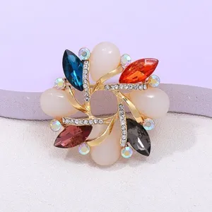 Detailed close-up of a vibrant multi-color crystal rhinestone floral brooch with gold tone.