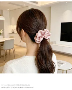 Pink satin hair scrunchie with delicate floral print, elegant ponytail holder for women styling.
