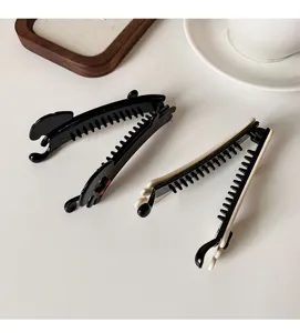 Close-up detail of cute puppy banana hair clip, minimalist vertical claw hair styling accessory.
