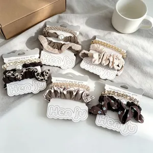 Set μαύρα scrunchies με καρό και μονόχρωμα σχέδια με πέρλες για καθημερινό styling.