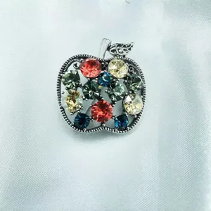 Colorful crystal apple brooch for women, elegant silver-plated metal coat pin accessory.