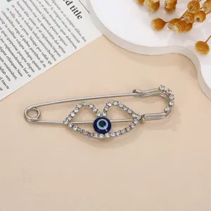 Detailopname van de zilveren strass boze oog broche met sprankelende kristallen.