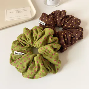 Groene en bruine gestippelde stoffen haarrekkers, elegante geplooide haarbanden voor dames.