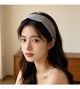 Gros plan d'un serre-tête en tissu sergé gris porté par un modèle, montrant texture et style.
