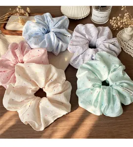 Gedetailleerd overzicht van schattige stoffen haarelastiekjes met pastelstippen voor leuk styling.