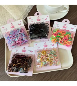 Detailed view of colorful elastic hair bands in five packages on a tray, perfect for kids hairstyles.