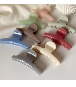 Toma de detalle que muestra pinzas para el pelo minimalistas curvas y lisas multicolores.