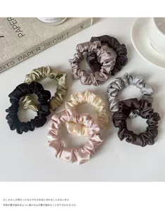 Detailed view of elegant satin hair scrunchies in multiple colors, soft seamless elastic bands.