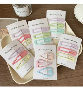 Mollette per capelli geometriche e a cuore pastello su cartoncini, dolci colori macaron graziosi.