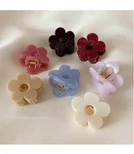 Close-up view of small flower hair claws, colorful resin shark clips for half updo hairstyles.