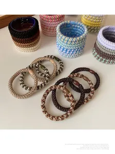 Close-up detail of colorful braided hair ties and scrunchies, showing neat texture and chic design.